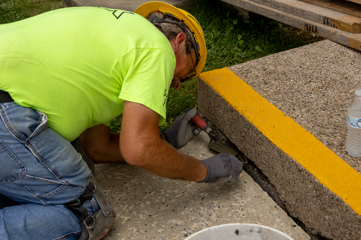Houck team member repairing cracked concrete steps.