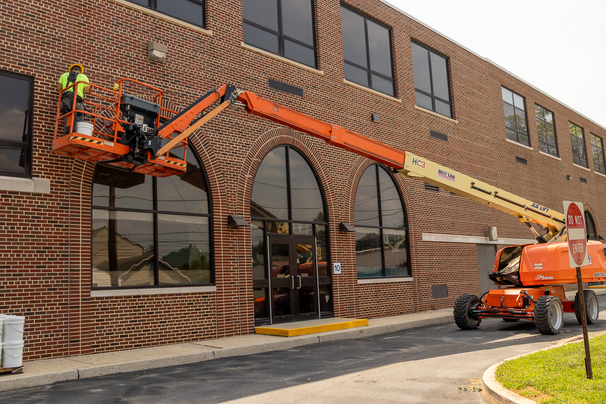 Houck team member repairing damaged brick facade around windows.